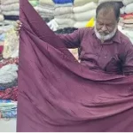 close up of hands weaving on traditional loom, warm lighting, artisanal detail