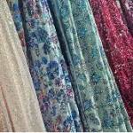 fashion designer and artisan collaborating on textile design, creative workspace